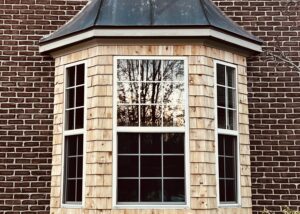 A bay window shingled with cedar shakes.